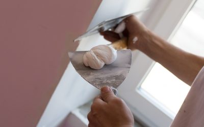 House painter skimming wall Craftsman skimming part of wall beside window.Home renovation concept