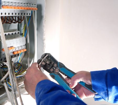Electrician works with internet cable conneting. Electrical swit Electrician works with internet cable conneting. Electrical switchboard with automats and wires.